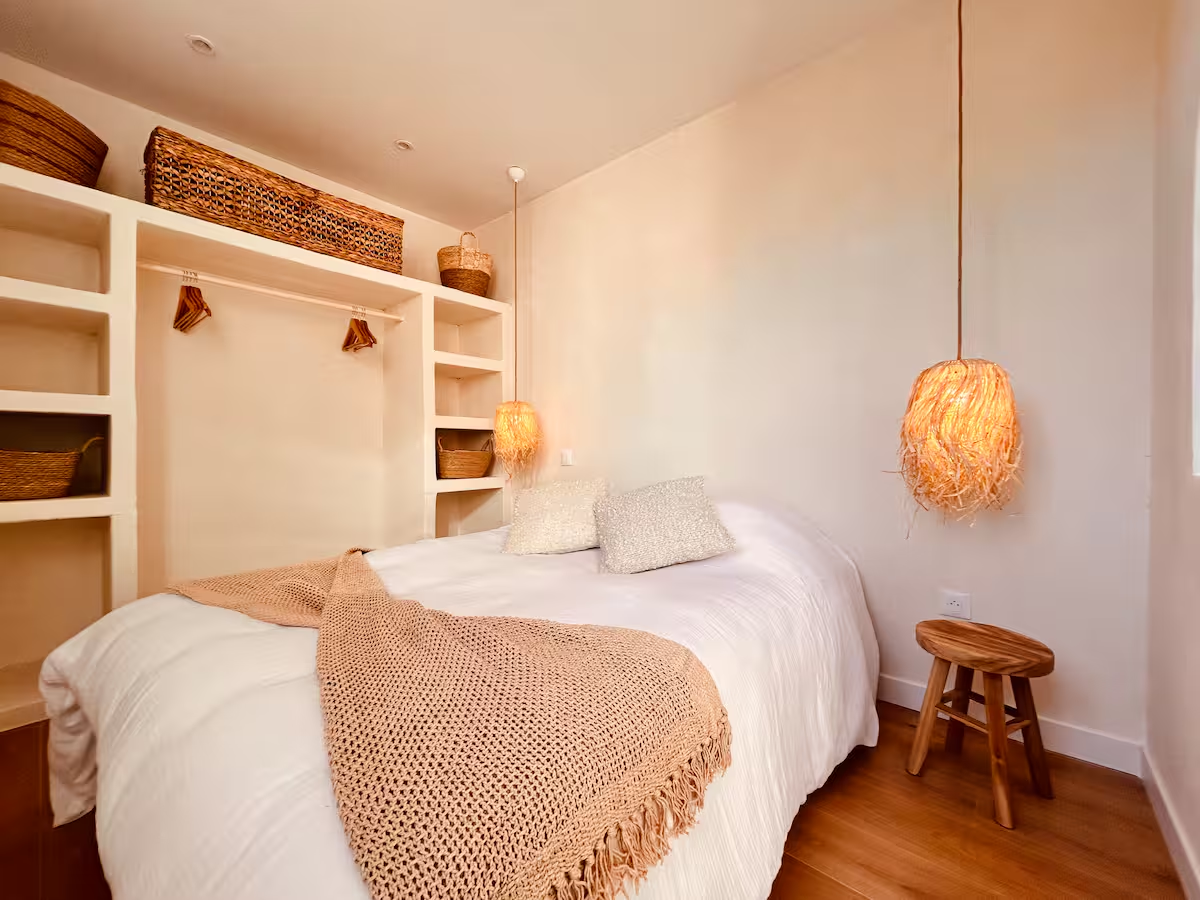 Chambre lumineuse avec linge blanc et décoration en fibres naturelles