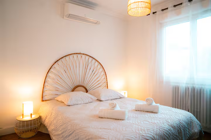 Chambre avec tête de lit en rotin et linge clair
